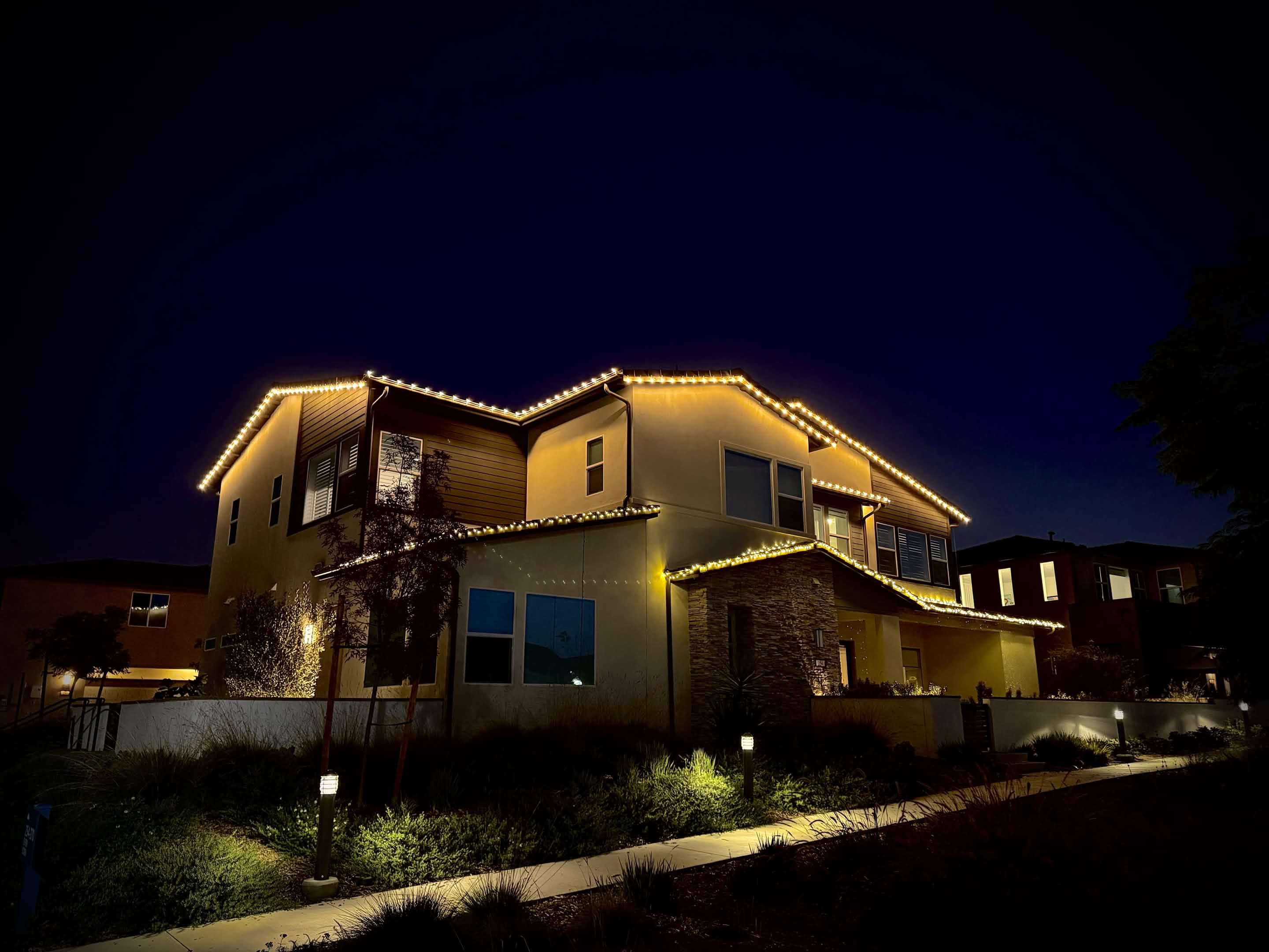 Warm white roofline lighting on a modern two-story home